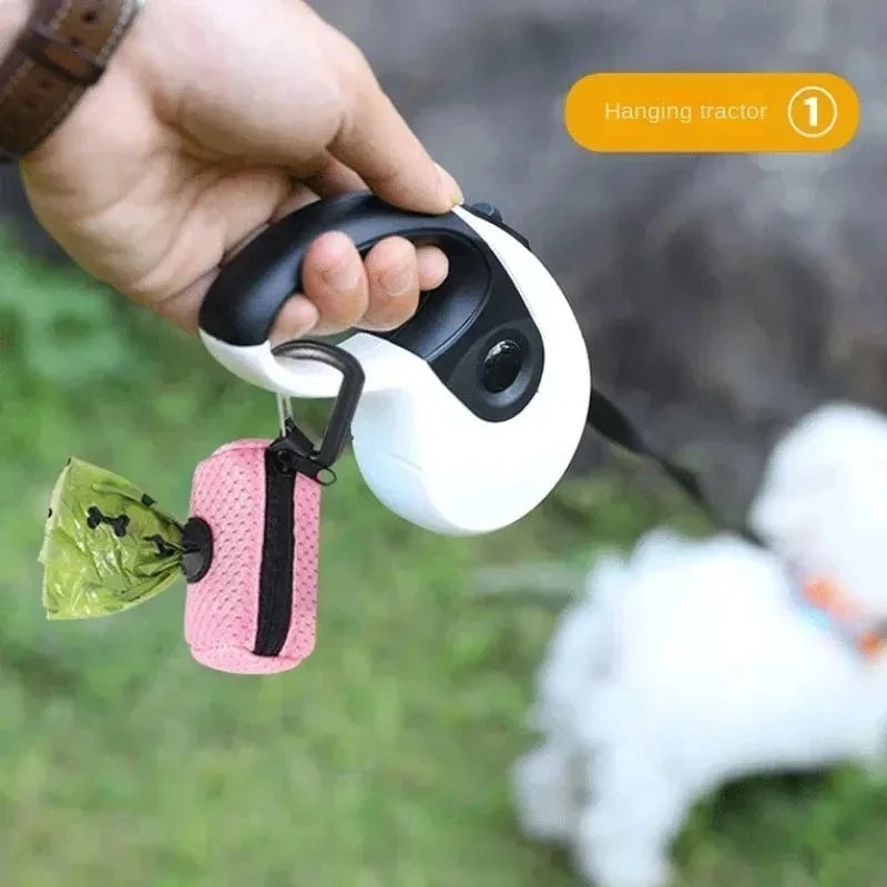 Pink mesh dog poop bag dispenser hanging from a retractable leash for easy waste cleanup while walking your dog.