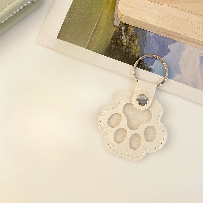 Cream leather cat paw keychain storage bag, a cute multifunctional pet hair charm for keys or bag accessory.