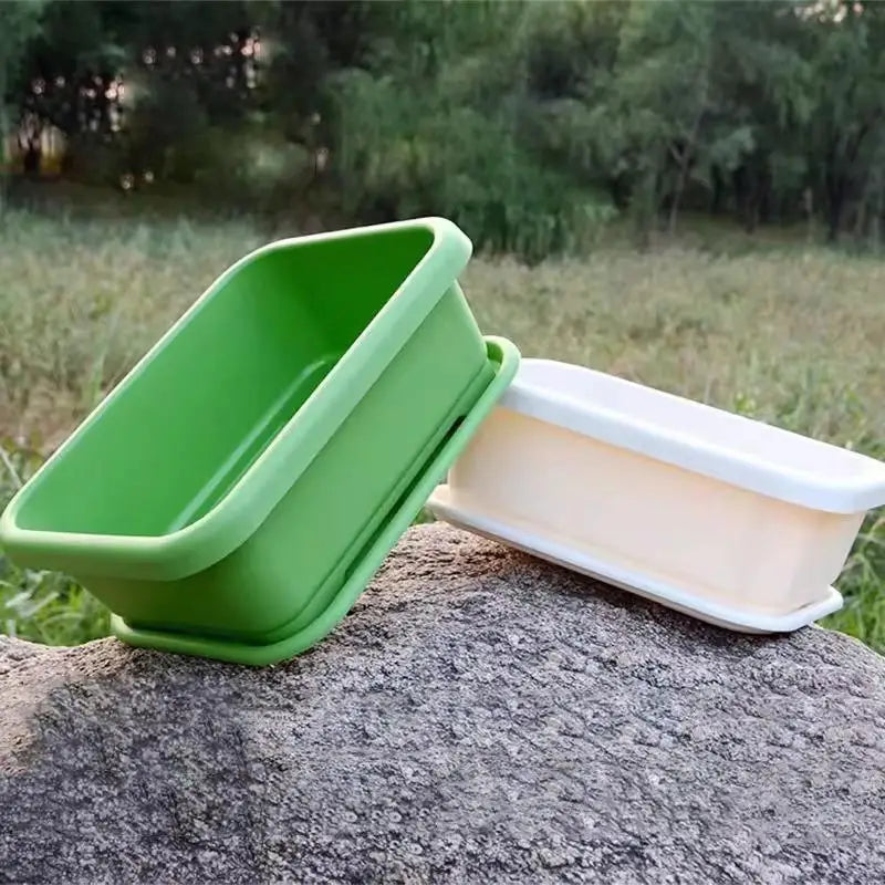 Green rectangular planter with white sliding tray insert on outdoor stone surface