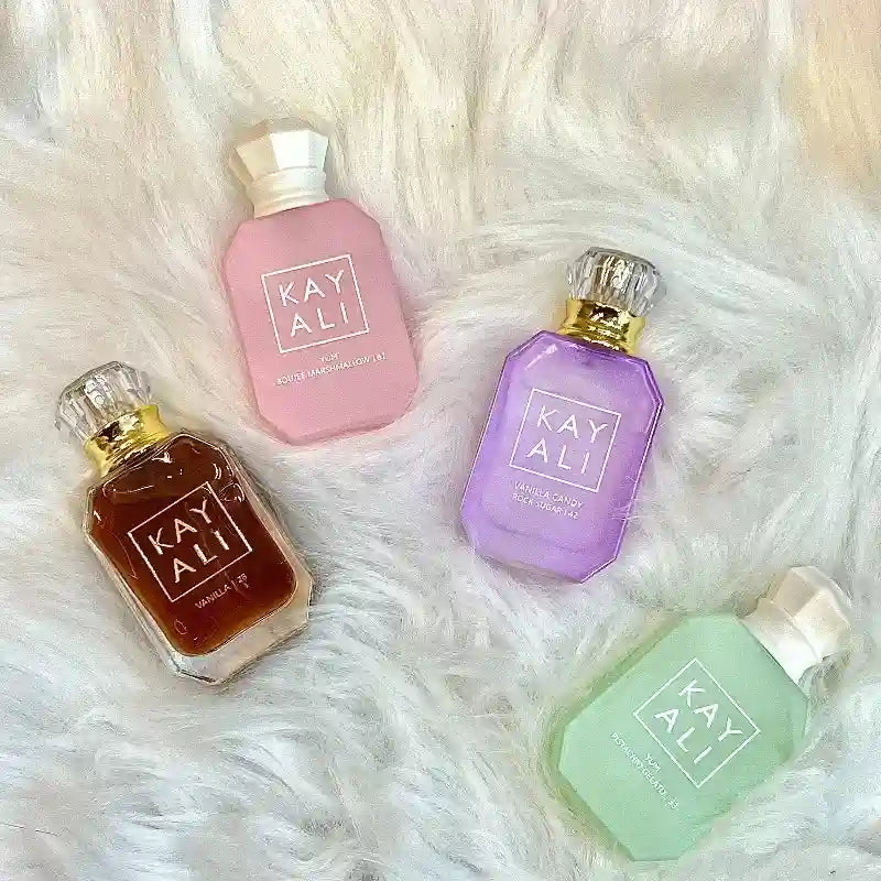 KAYALI unisex travel perfume set: 4 mini glass bottles with sweet oriental fragrance notes on a white fur background.