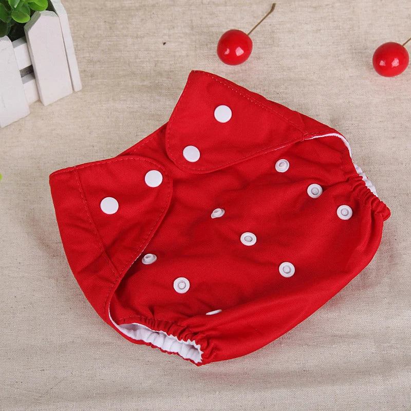 Red adjustable cloth baby diaper with white snap closures, designed for reusable infant care.