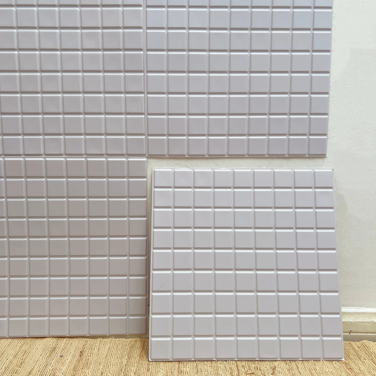 Peel-and-stick square backsplash tiles, light beige textured grid pattern