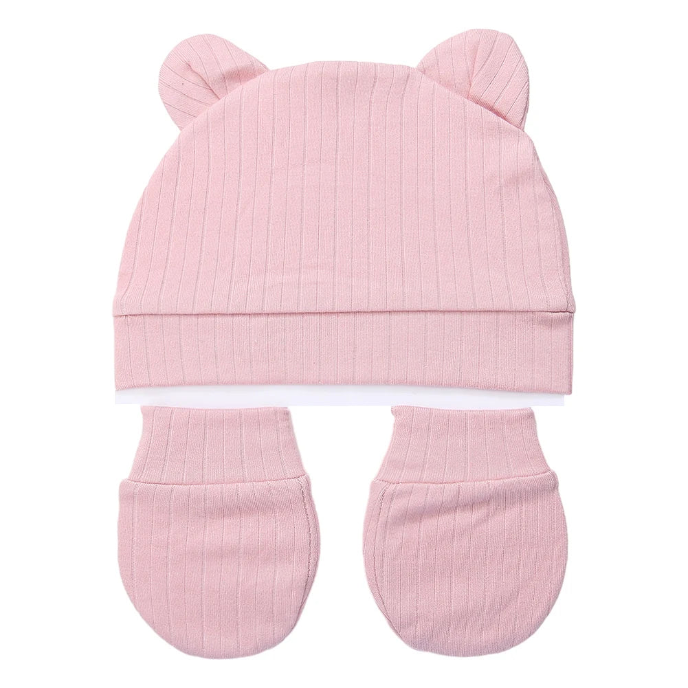 Tidesmit 3-piece newborn set in ribbed light pink cotton featuring a bear-ear hat and two matching scratch mittens.