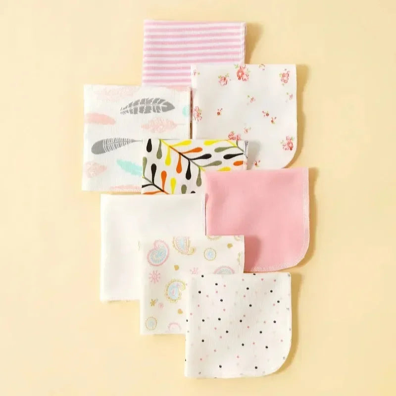 Set of 8 baby care washcloths with assorted floral, feather, and polka dot prints for gentle infant skin care.