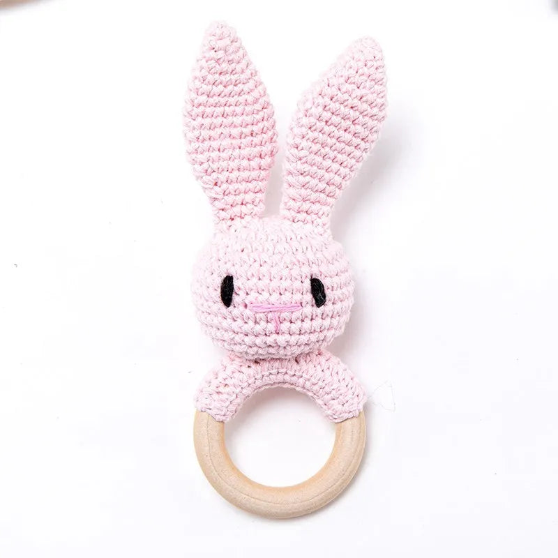 Pink rabbit teething ring toy made with natural wood and cotton for baby teething relief.
