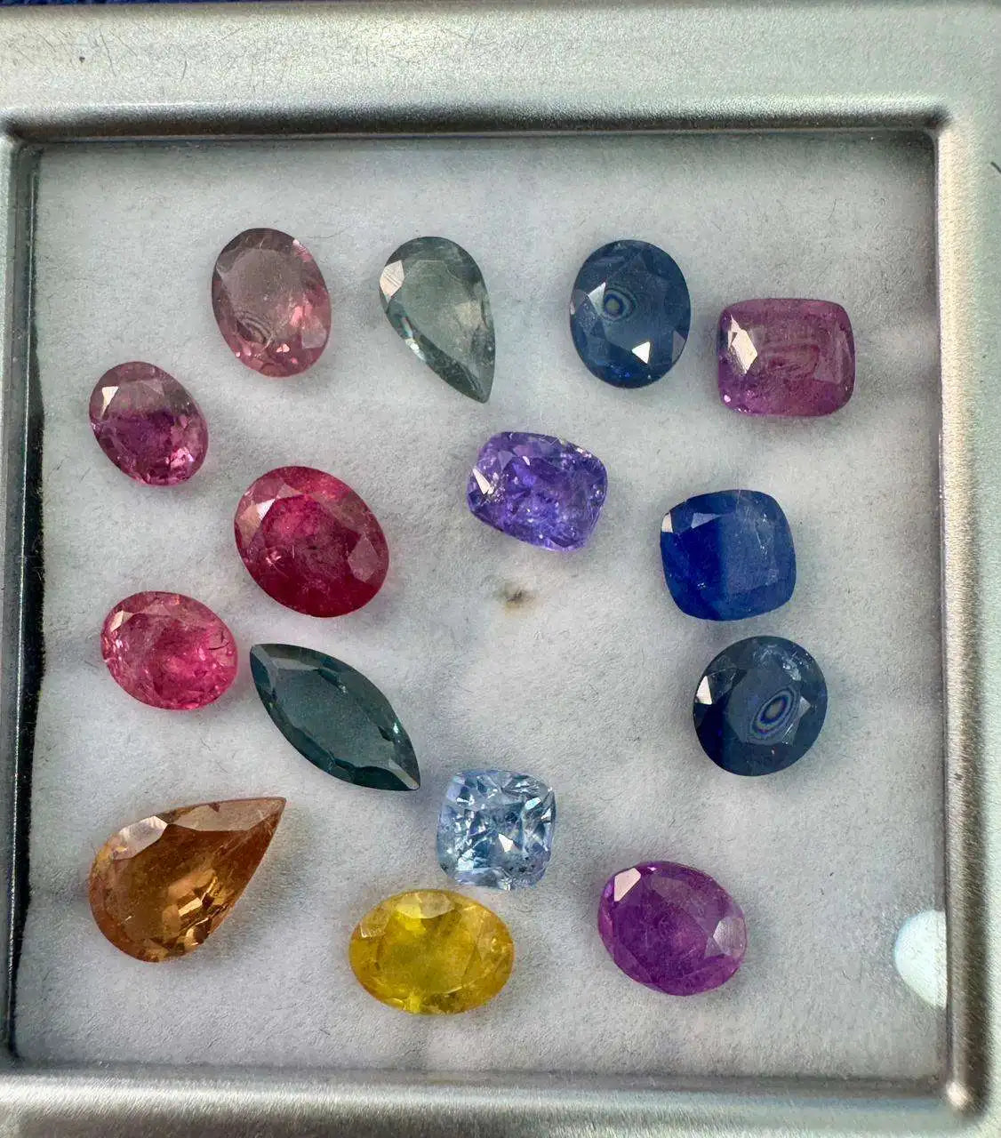 Natural sapphire gemstone mix in metal tray, pink, blue, green, yellow and purple stones
