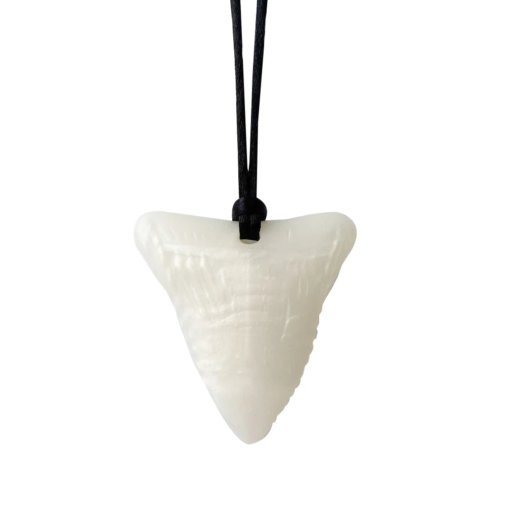 White silicone shark tooth baby teething toy necklace on a black cord for soothing relief.