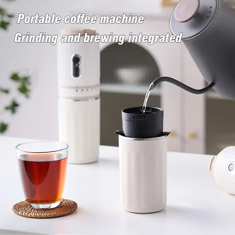 White portable coffee machine with integrated grinder and pour-over dripper set on a white table.