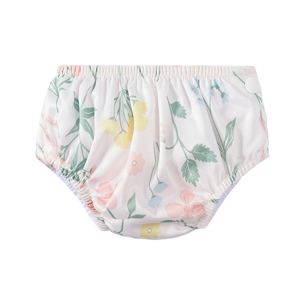 Reusable baby swim diaper with white floral print and snap-side design for comfortable baby care.