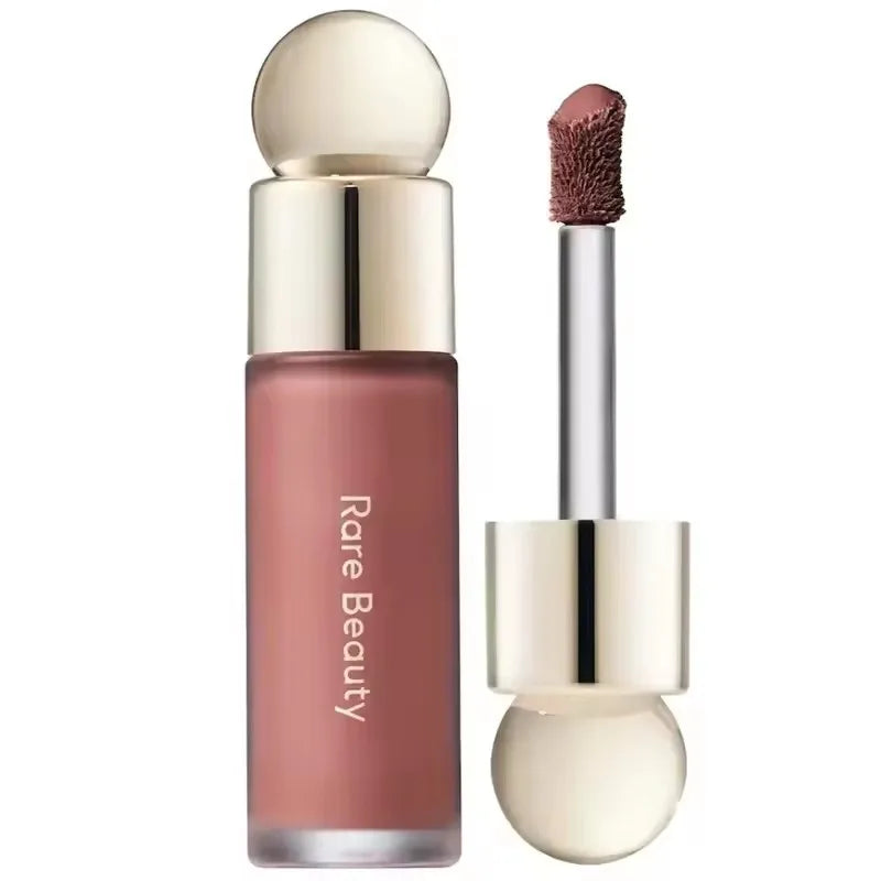 Rare Beauty matte liquid lipstick with applicator, rich mauve color, smooth texture, and gold cap packaging.