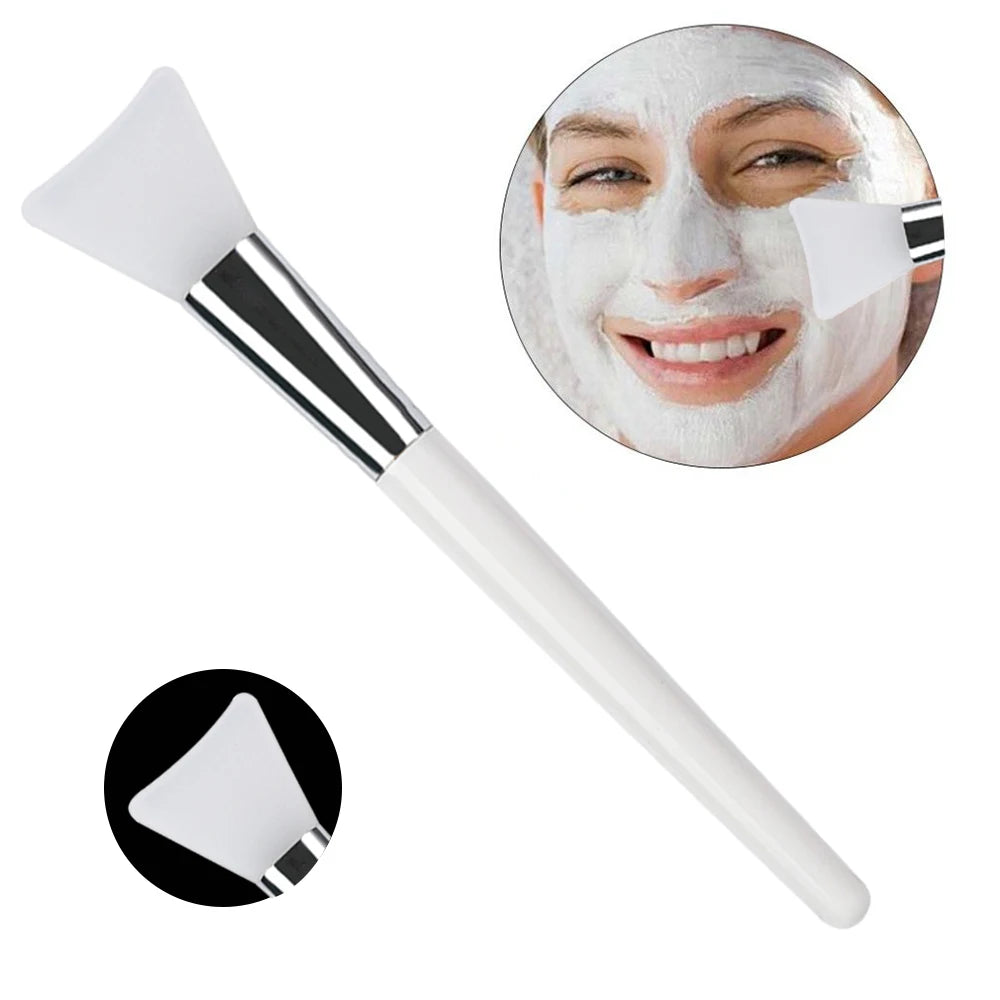 White silicone face mask applicator brush with a silver ferrule and a white handle, shown applying a facial mask.