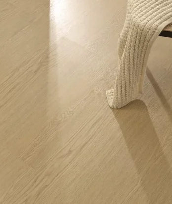 SPC click flooring plank surface with light wood grain and chair edge in view