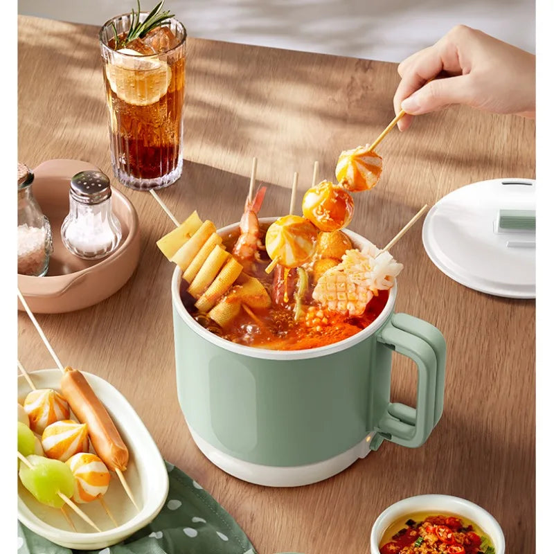 Electric hot pot cooker with mint-green pot, side handle, and open lid on table