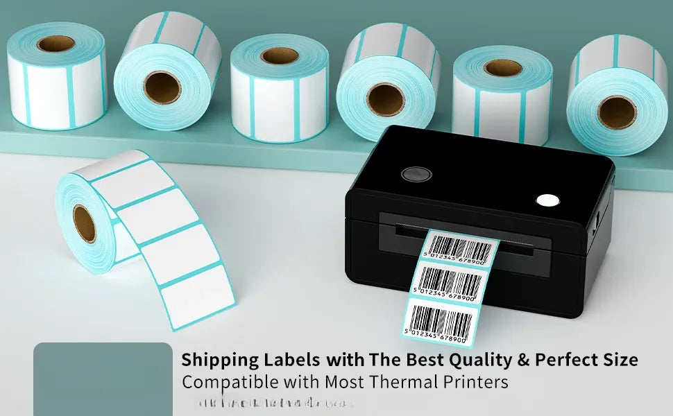 Multiple white thermal label rolls with light-blue edges beside a black thermal printer