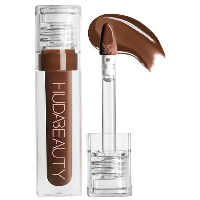 Huda Beauty brown hydrating lip and cheek tint stick with creamy texture and doe-foot applicator swatch.