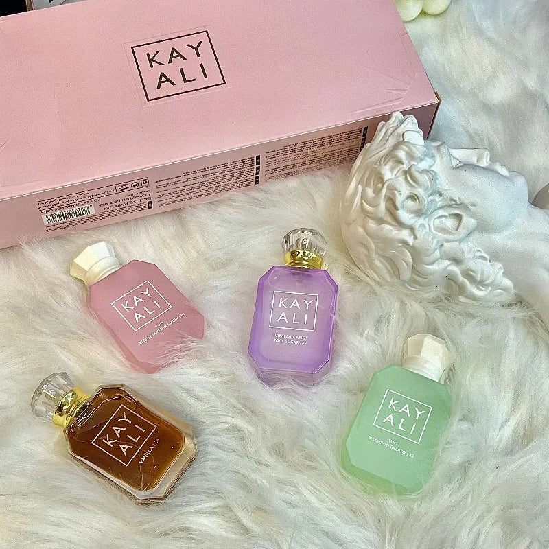 KAYALI unisex EDP perfume set: 4 luxury travel bottles with vanilla, pistachio, and oriental scents on a white rug.