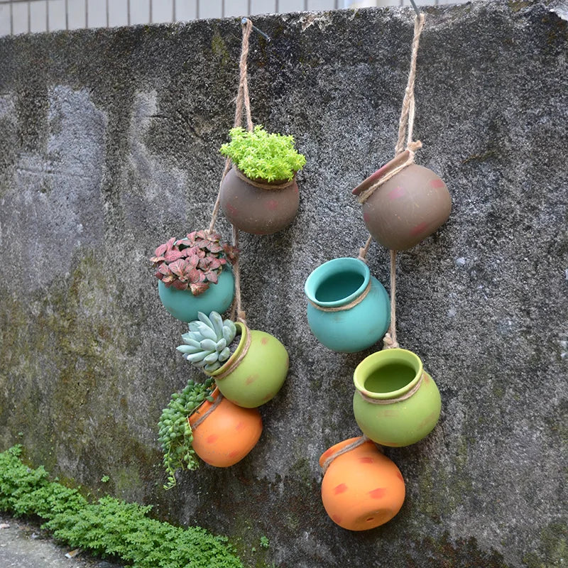 Set of 4 hanging ceramic planters in orange and green with succulents