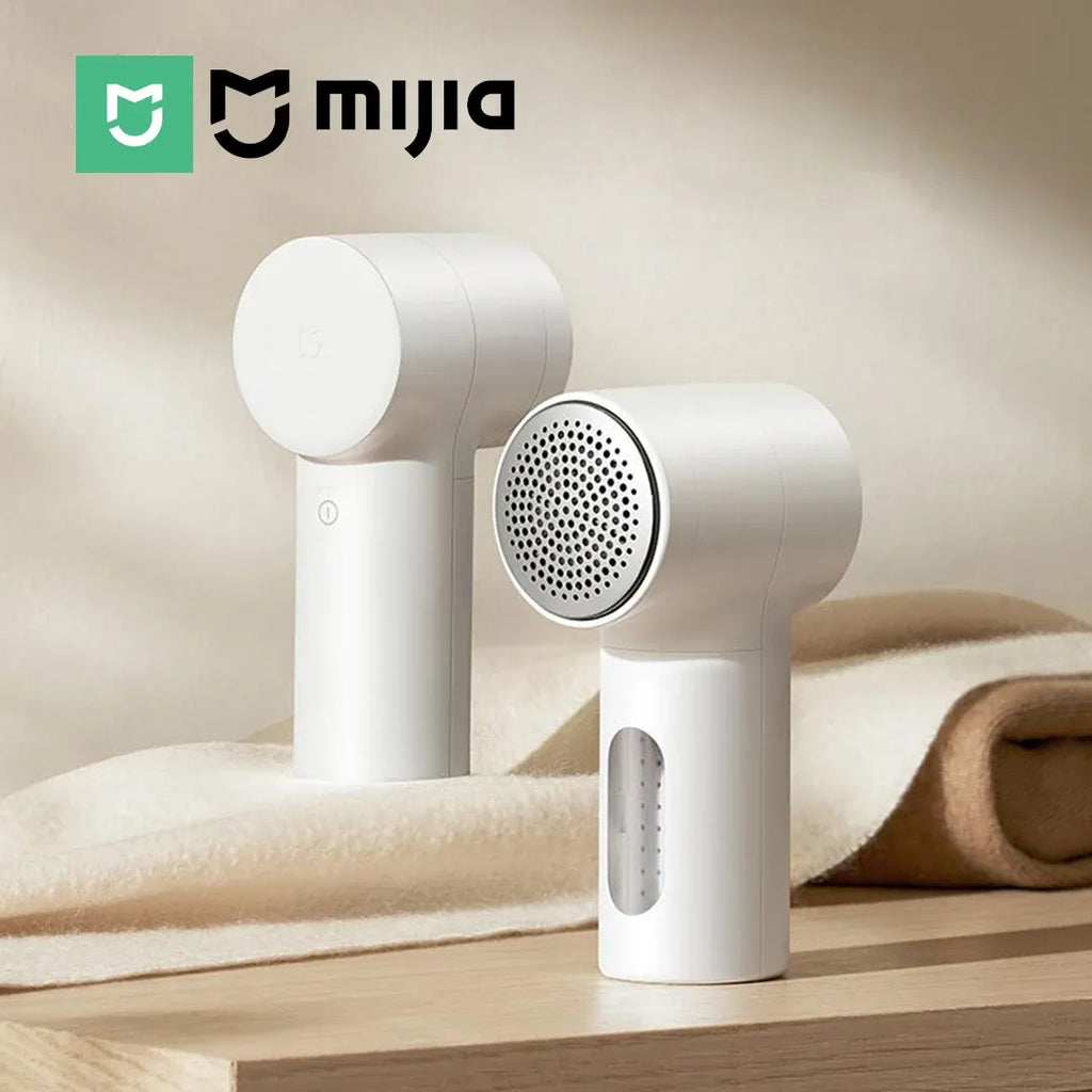 Xiaomi Mijia lint remover fabric shaver resting on soft wool fabric on a wooden table.