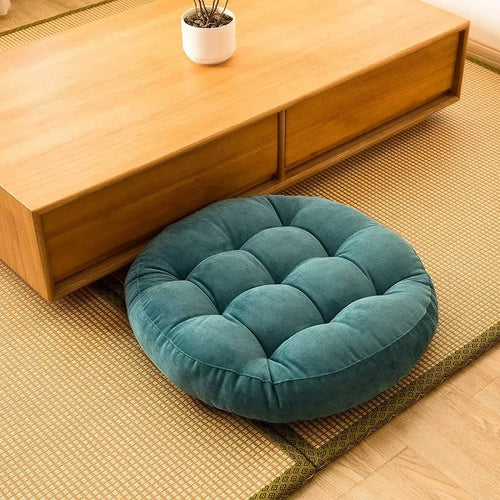 Teal velvet round meditation cushion for mindful yoga practice on a tatami mat.