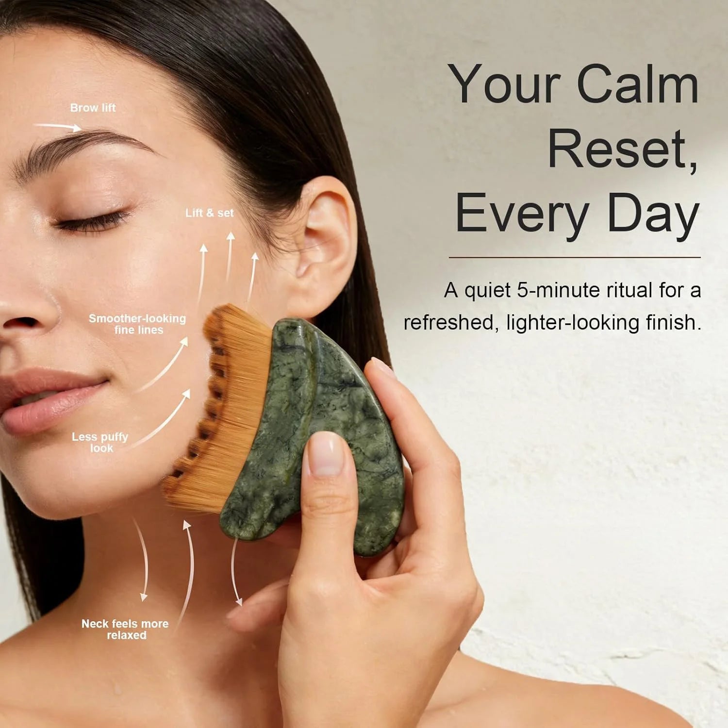 Woman using a green marble-style gua sha facial brush with soft brown bristles on her cheek.