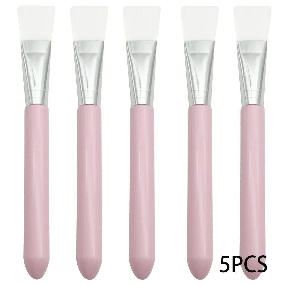 Five facial mask brushes with white silicone heads, silver ferrules, and rounded light pink handles.