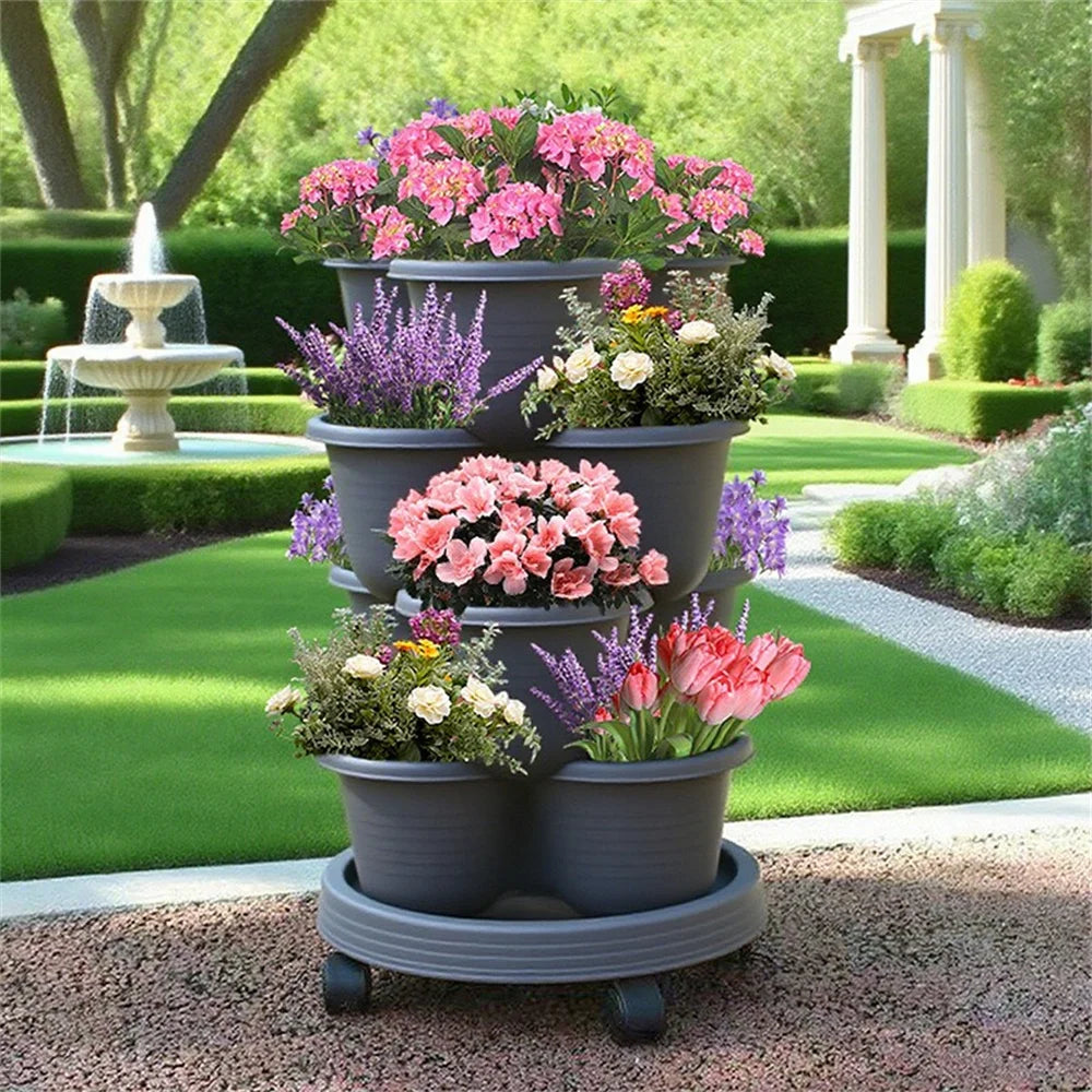 Stackable vertical garden planter with wheels, dark gray base and multiple pots with flowers.