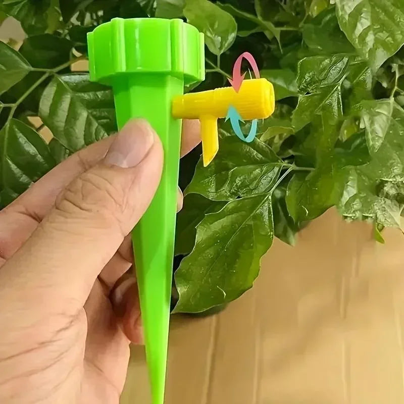 Green adjustable drip irrigation spike with yellow connector, held in hand near leaves.