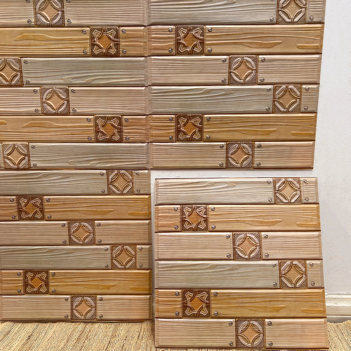 Peel-and-stick woodgrain backsplash tiles with small square medallion accents