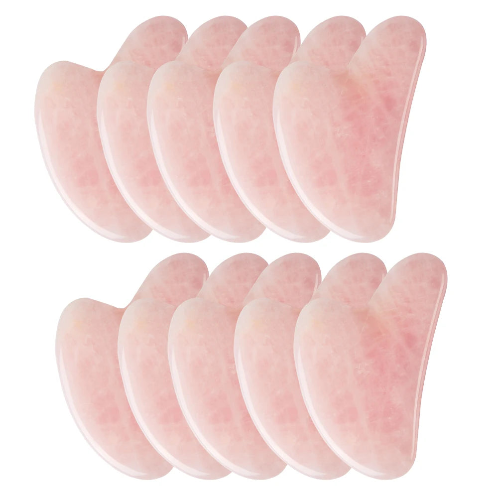Ten heart-shaped rose quartz gua sha facial massage tools arranged in two rows against a white background.