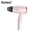 Kemei portable pink travel hair dryer with concentrator nozzle, foldable handle, and compact 950W design.