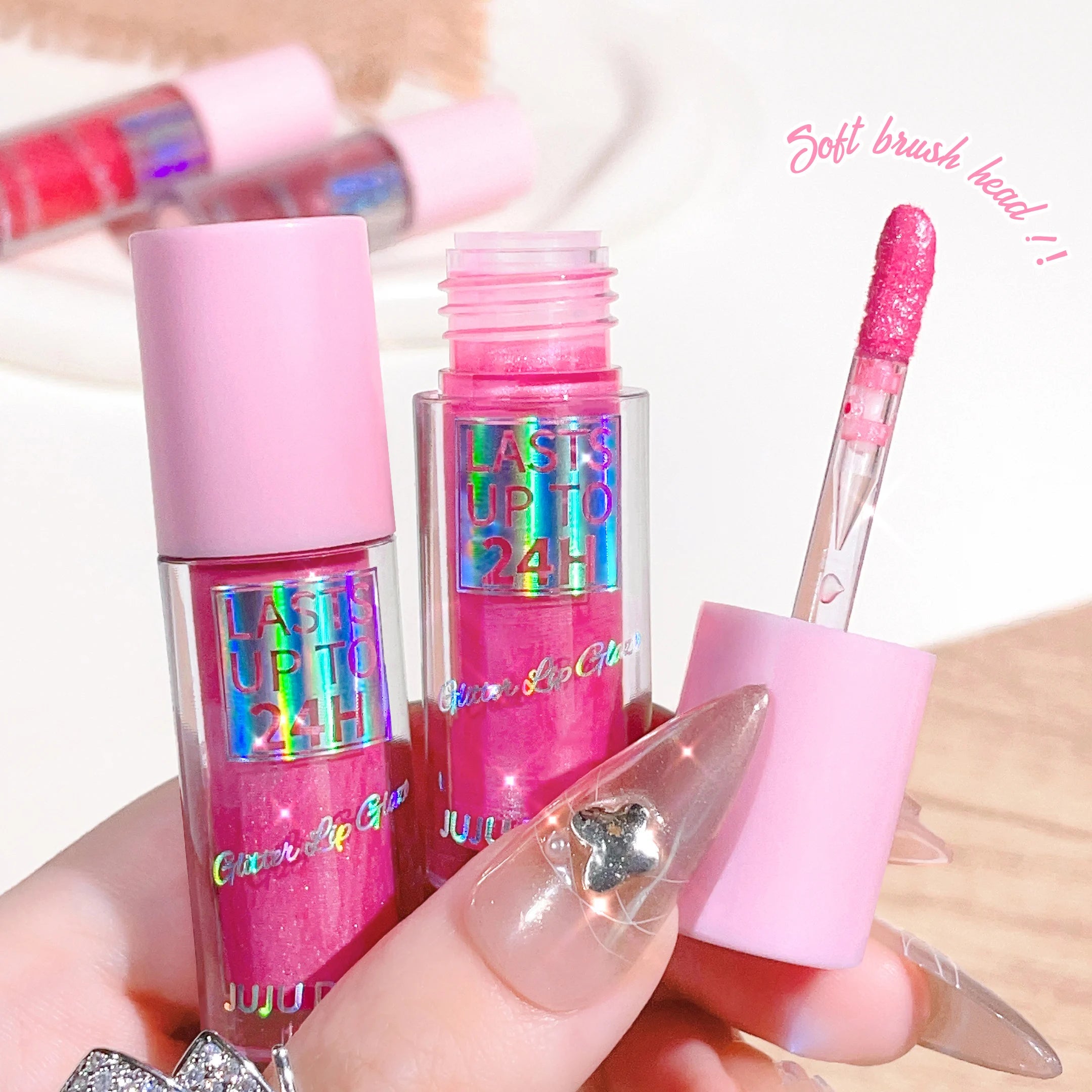 Long-lasting pink glitter lip glaze with applicator, featuring a waterproof, shimmering formula in a clear tube.