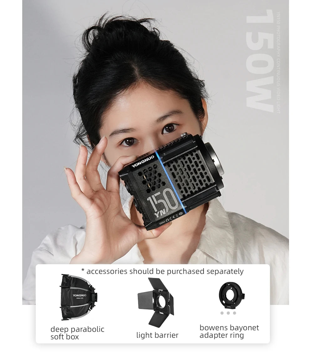 Compact 150W black LED video light with honeycomb vents, held by a person. Shows optional softbox, barn doors, and ring.