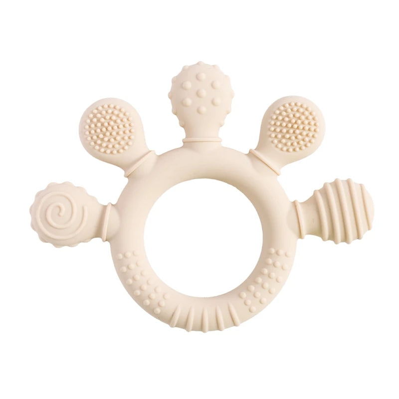 Beige silicone teething ring toy for baby teething relief with textured sensory surfaces.