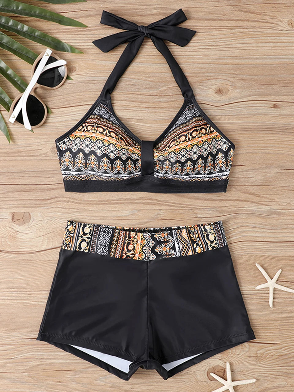 Tidesmit high-waisted bikini with black halter top, matching bottoms, and orange tribal pattern accents.
