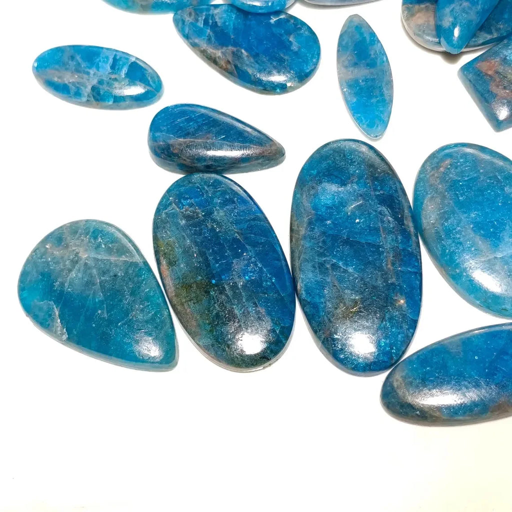 Ocean-blue cabochon gemstones, assorted oval and teardrop pieces in close-up