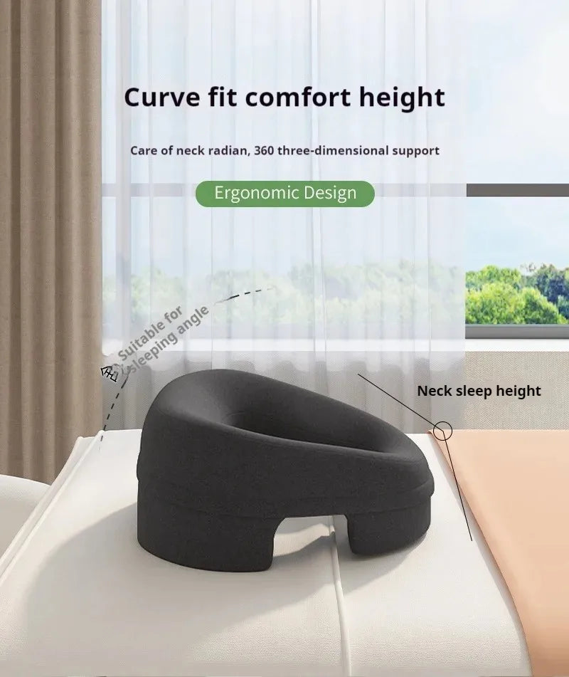 Ergonomic charcoal-grey foam prone massage pillow with a curved, cutout design for neck and breast support.