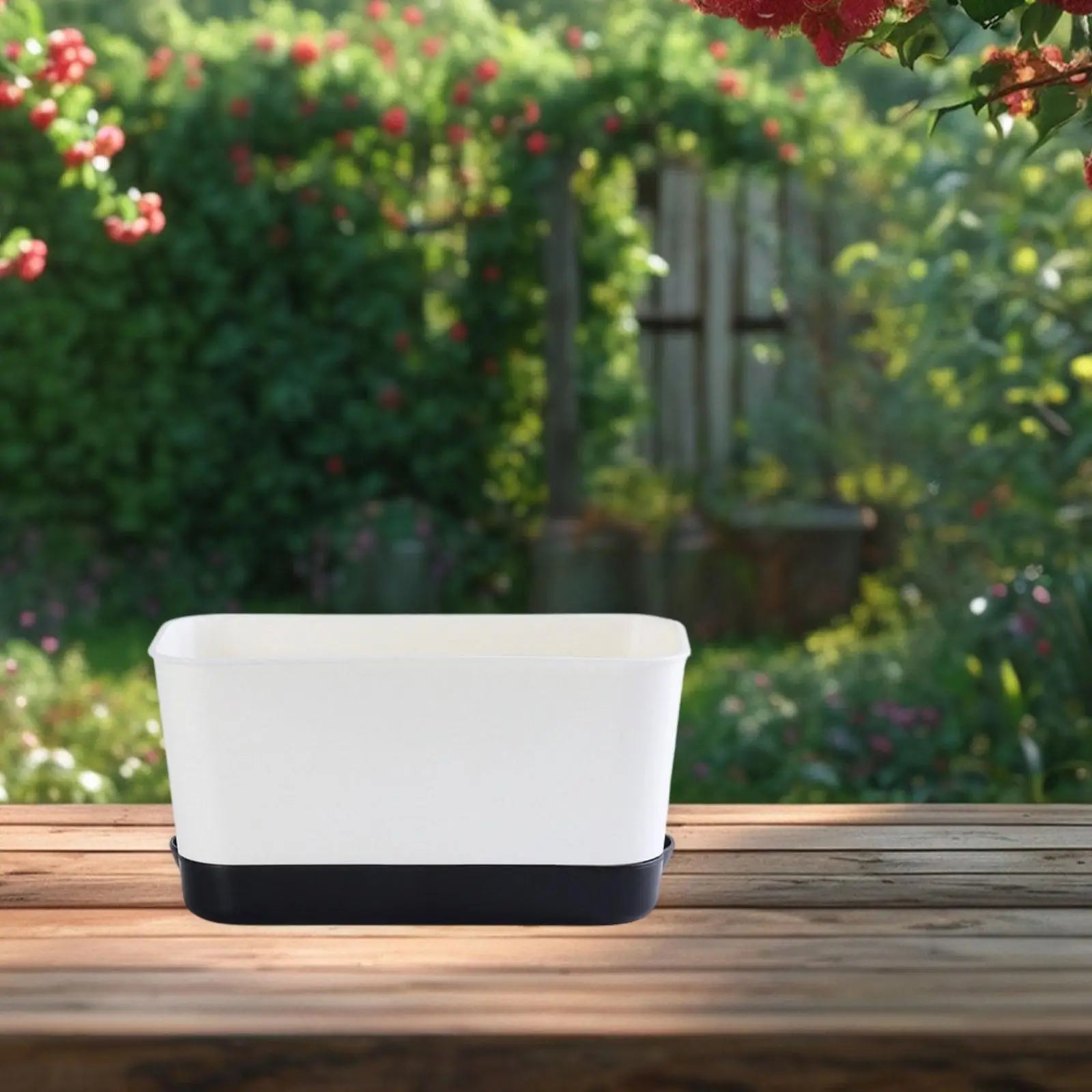 Rectangular window box planter with white body and black base on wooden deck.