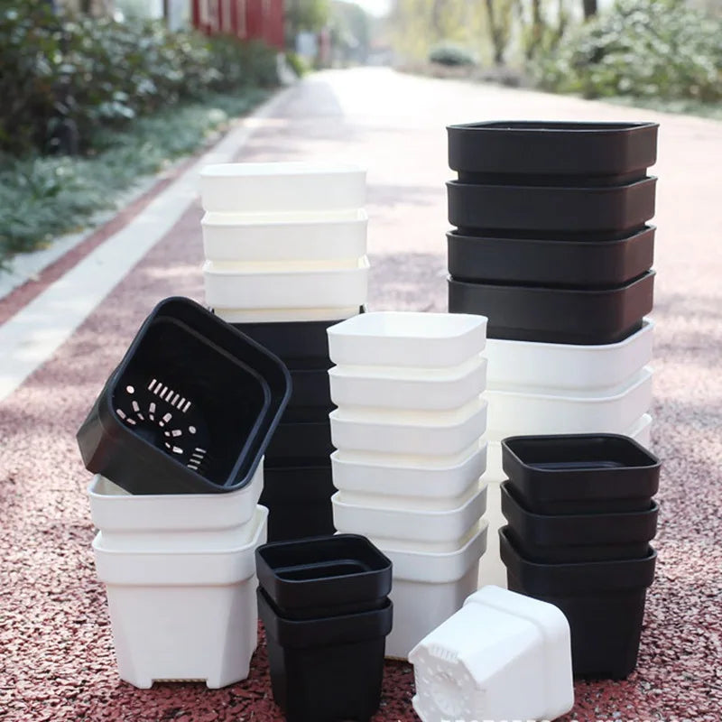 Stack of square succulent planter pots in black and white with drainage holes