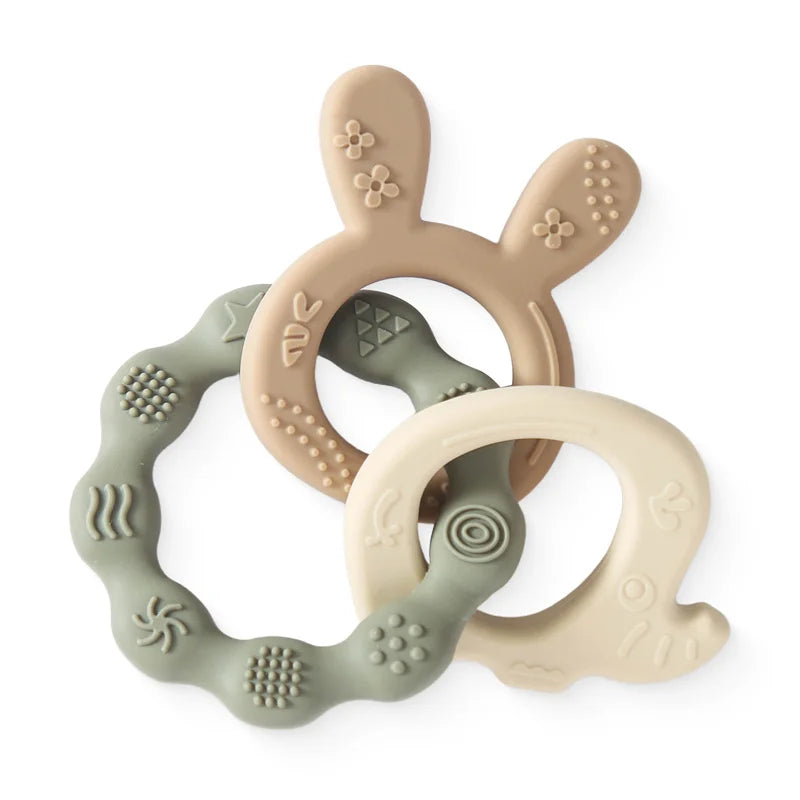 Beige and sage green silicone teething rings for baby teething relief.