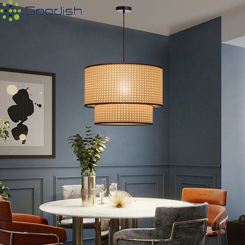 Two-tiered cylindrical rattan pendant light with black trim, suspended from ceiling for dining room lighting.
