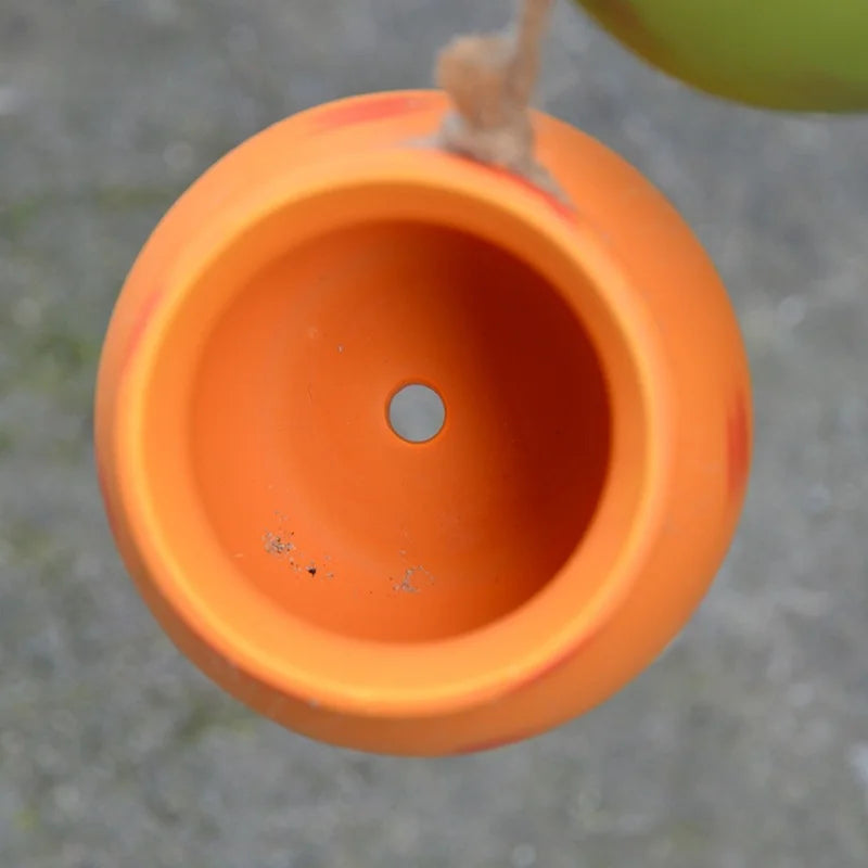 Orange hanging ceramic pot with open top and small drainage hole