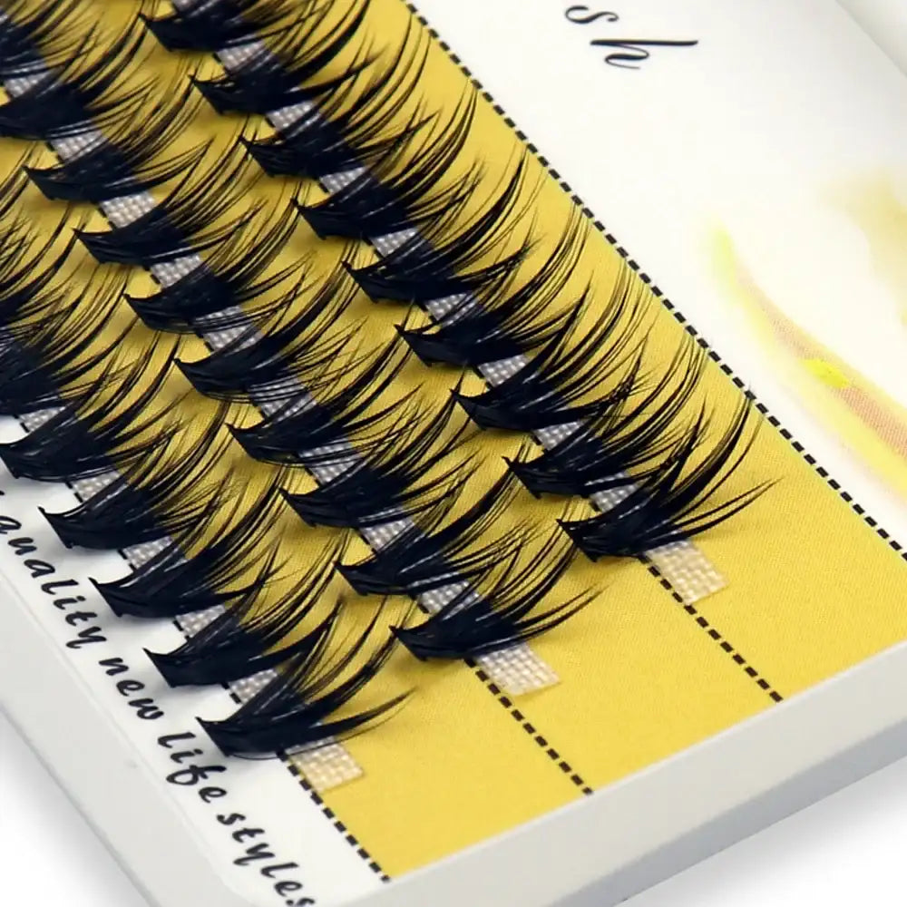A box of 20D/30D black individual mink eyelash clusters arranged in rows on a yellow backing card.