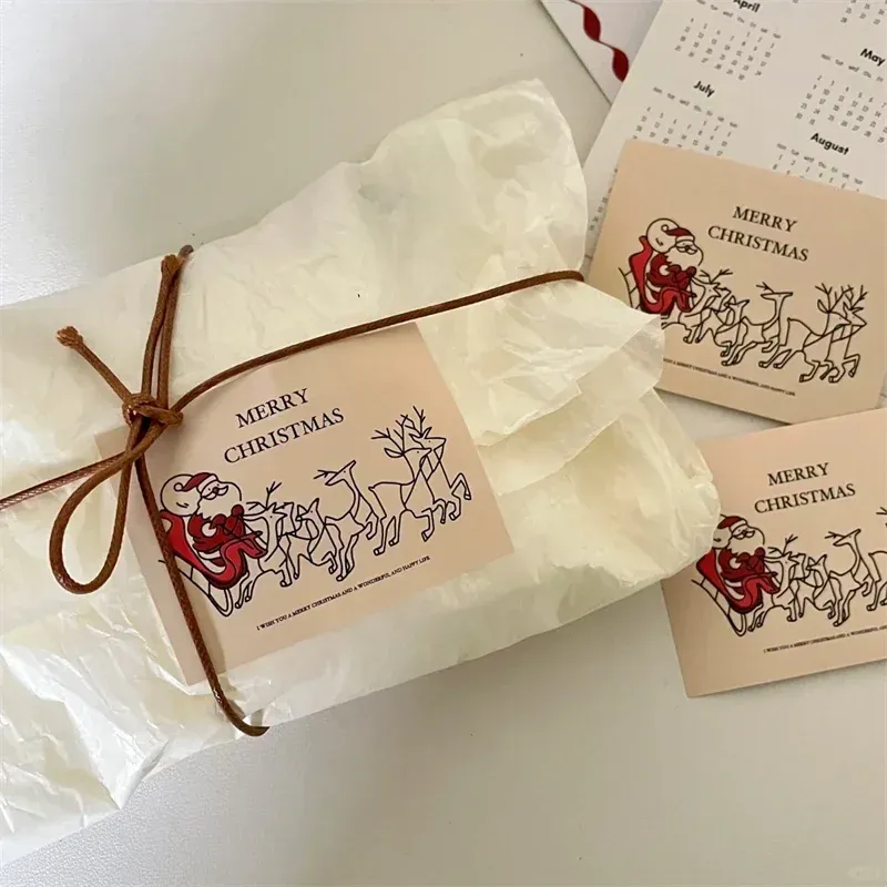 “MERRY CHRISTMAS” custom label stickers on brown gift wrap packages.