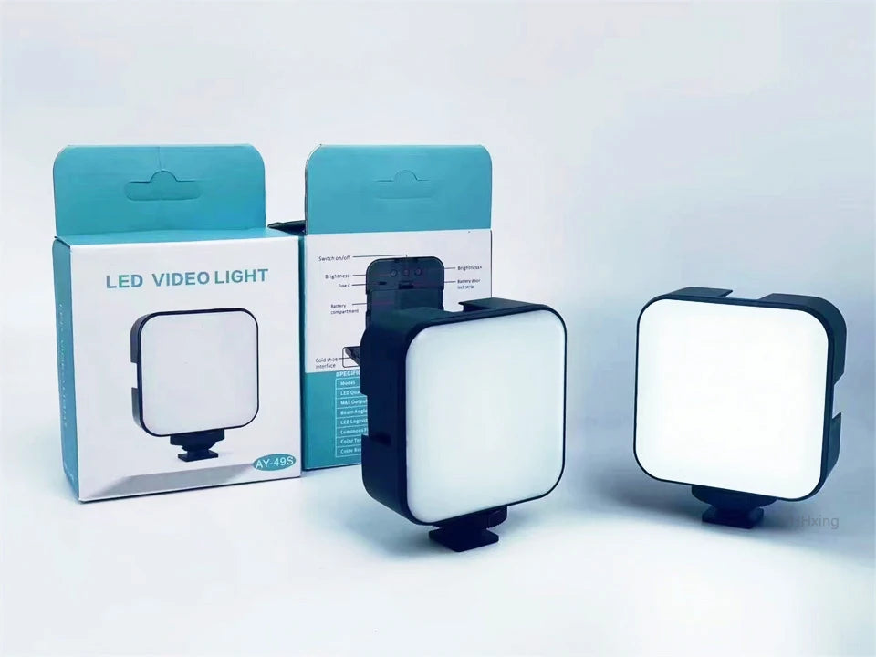 AY-49S square LED video light with cold shoe mount, white diffusion panel, and black plastic casing for photography.