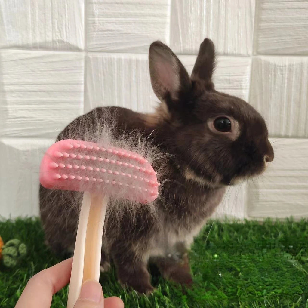 Pink silicone grooming comb removing loose fur from a brown pet rabbit, perfect for small animal hair care.
