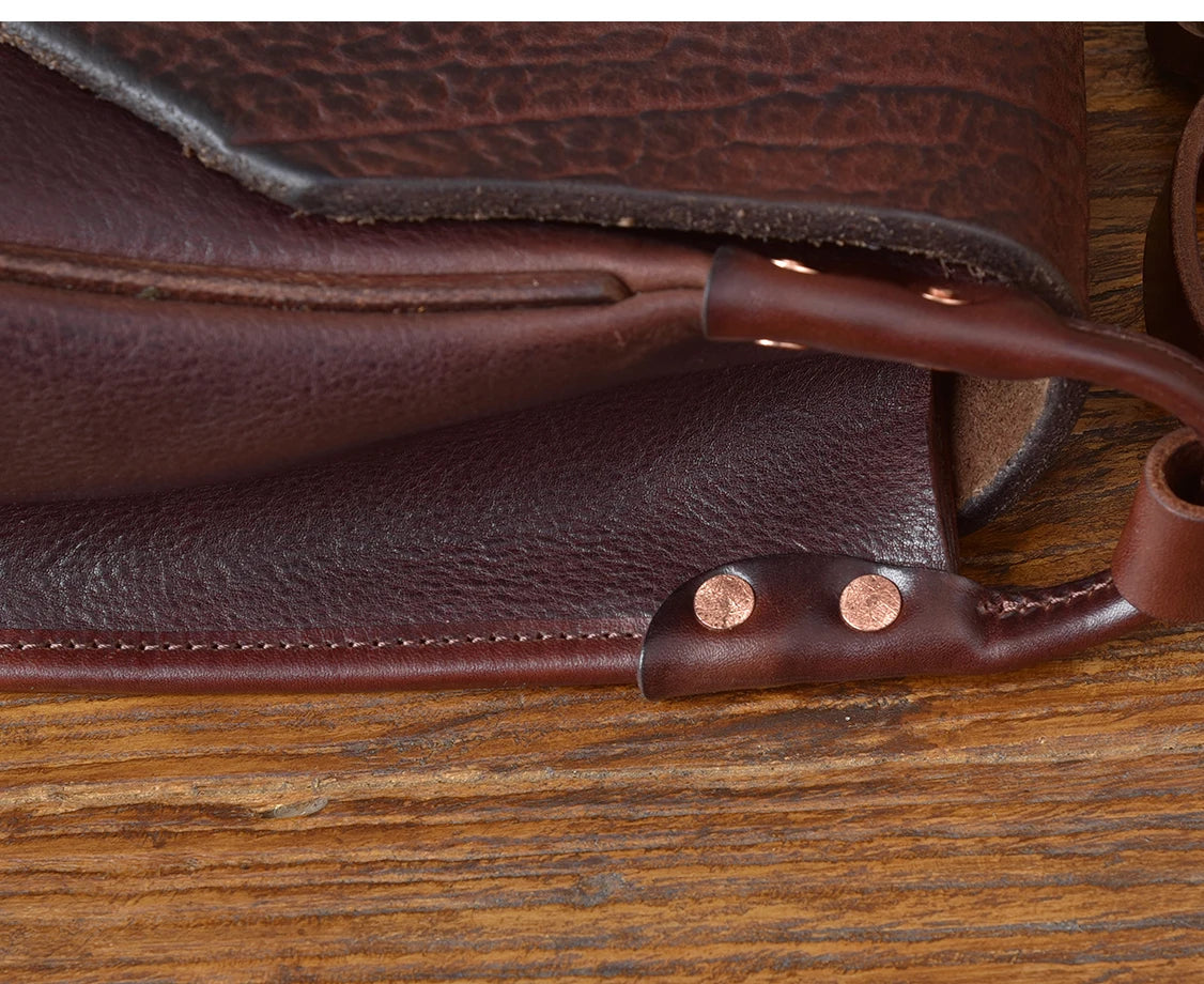 Dark brown handmade cowhide leather messenger bag with detailed stitching and copper rivet accents.