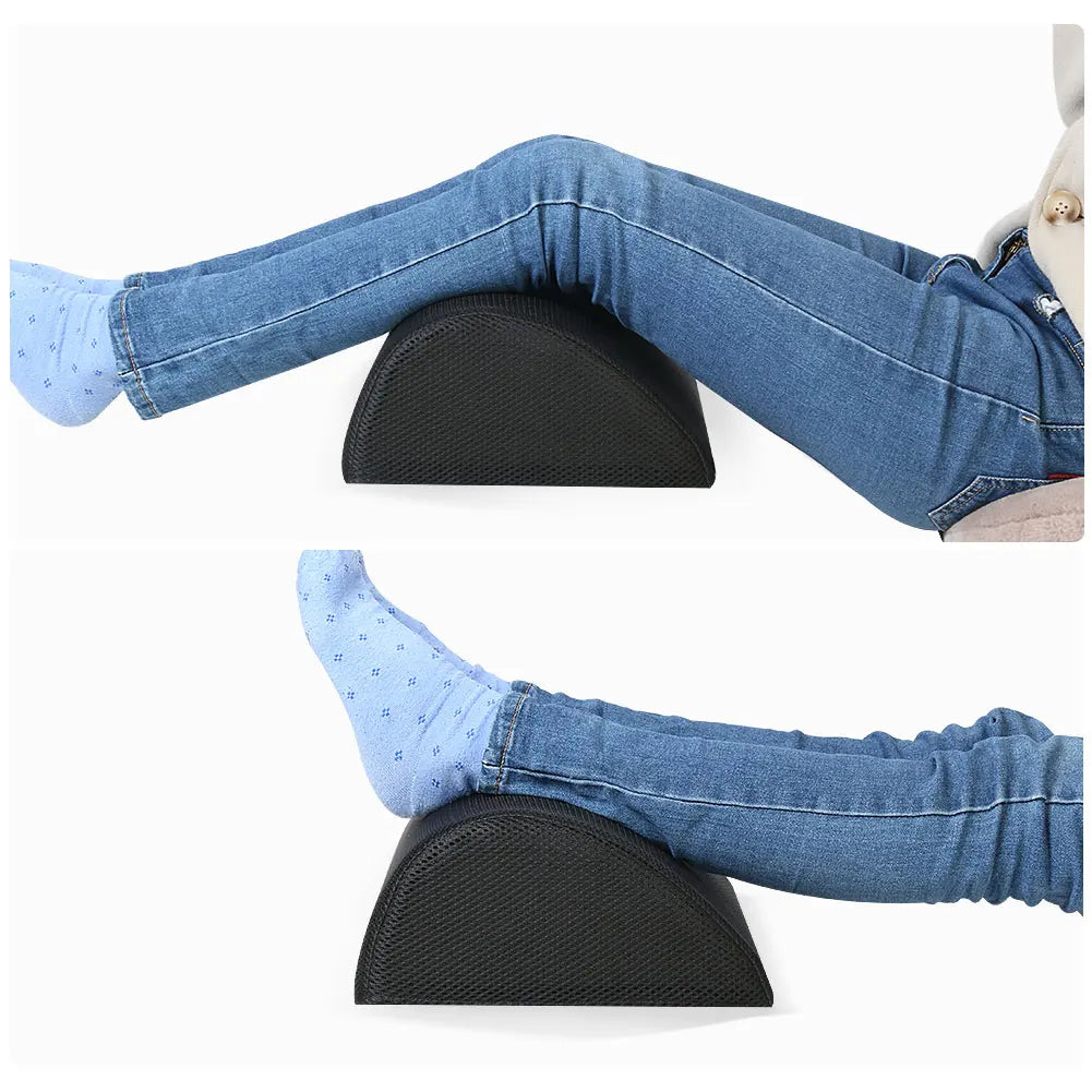Black memory foam leg lift pillow and ergonomic desk footstool for improved posture in home office or gaming setup.
