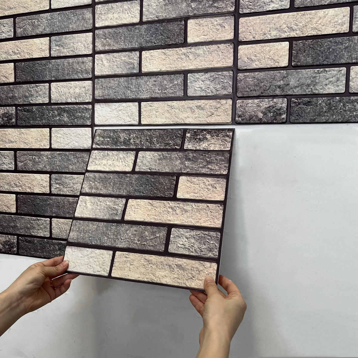 Peel-and-stick faux brick backsplash tile sheet in gray and cream tones