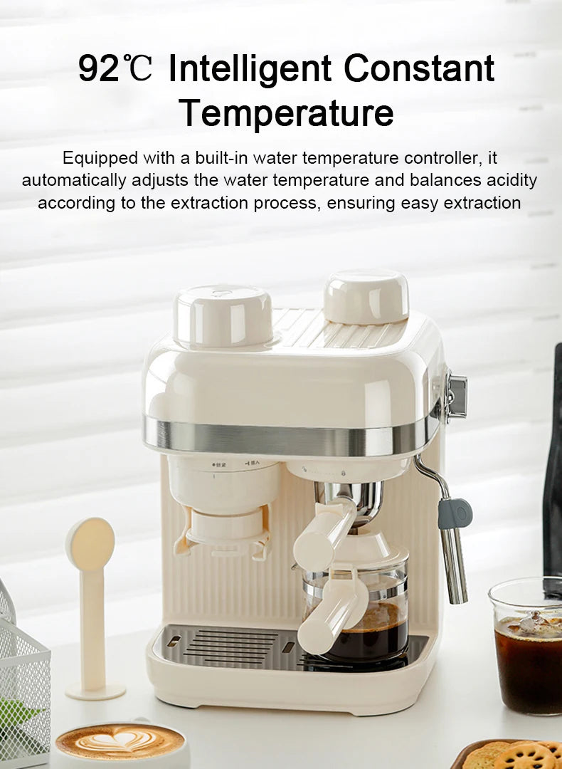 Cream-colored compact espresso coffee machine with glass carafe and integrated milk frothing wand on white surface.