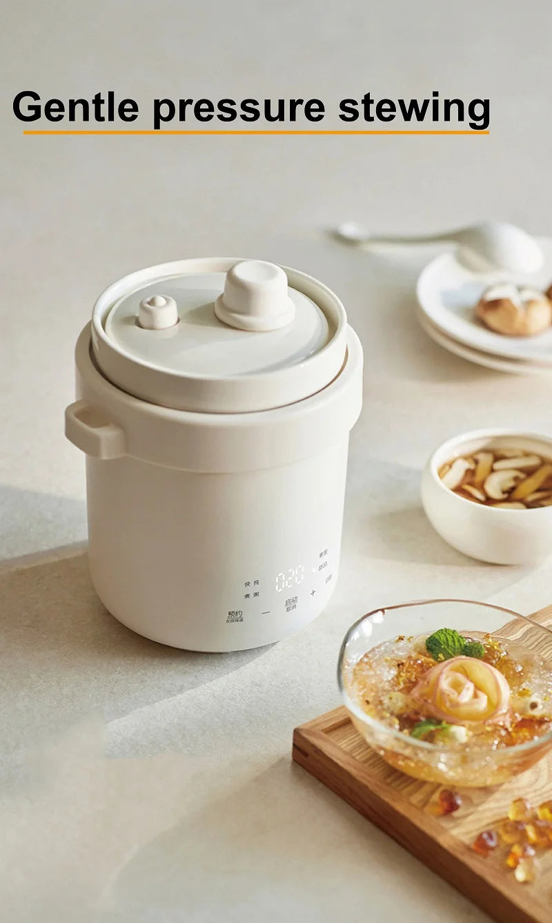 White mini electric stew pot on countertop with round lid and serving dish